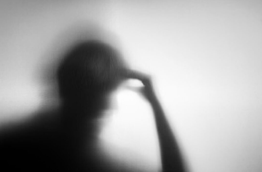 A silhouette of a senior person who is holding his head by his hand with a gesture of difficulty in remembering. When someone has dementia, they may not be able to make decisions or understand things in the same way that they used to
