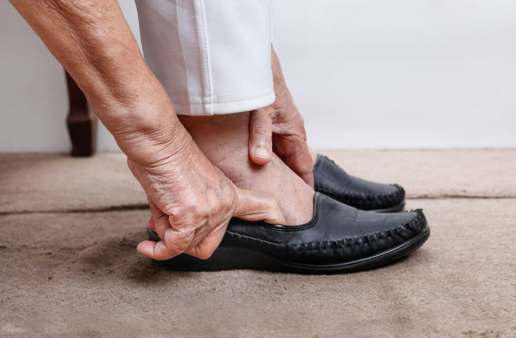 An older adult woman putting on slip on shoes