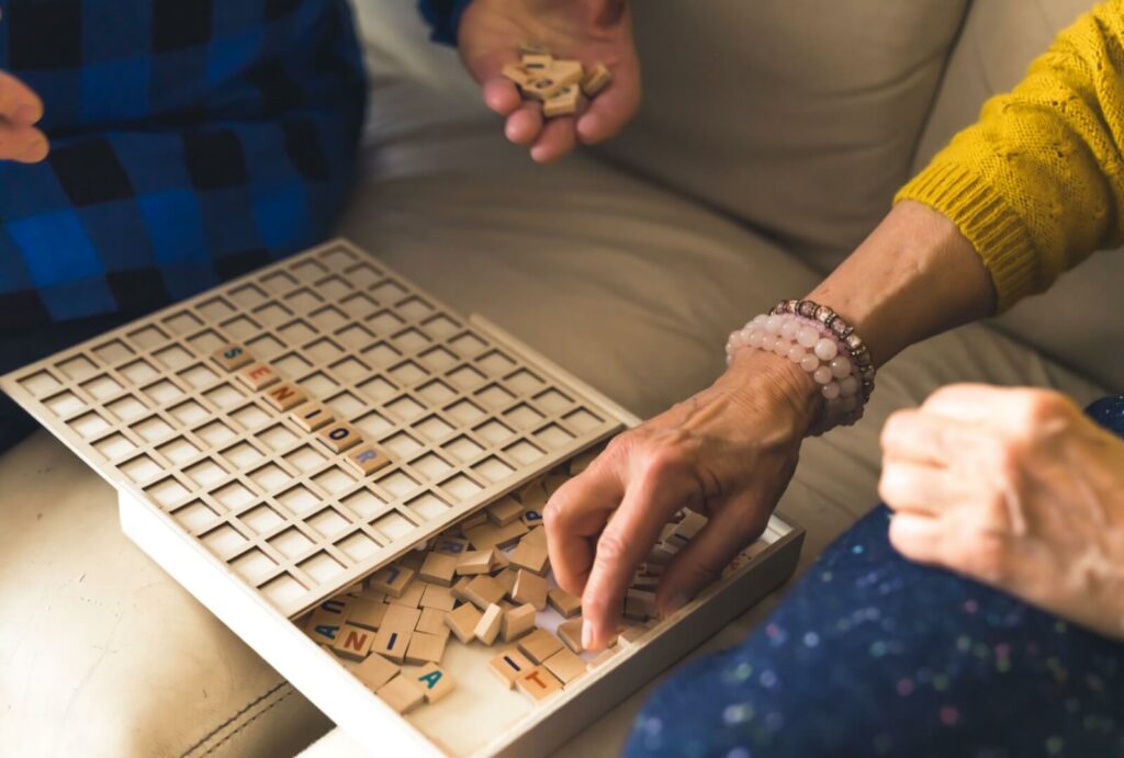 A close-up of people playing scrabble together at a senior living community